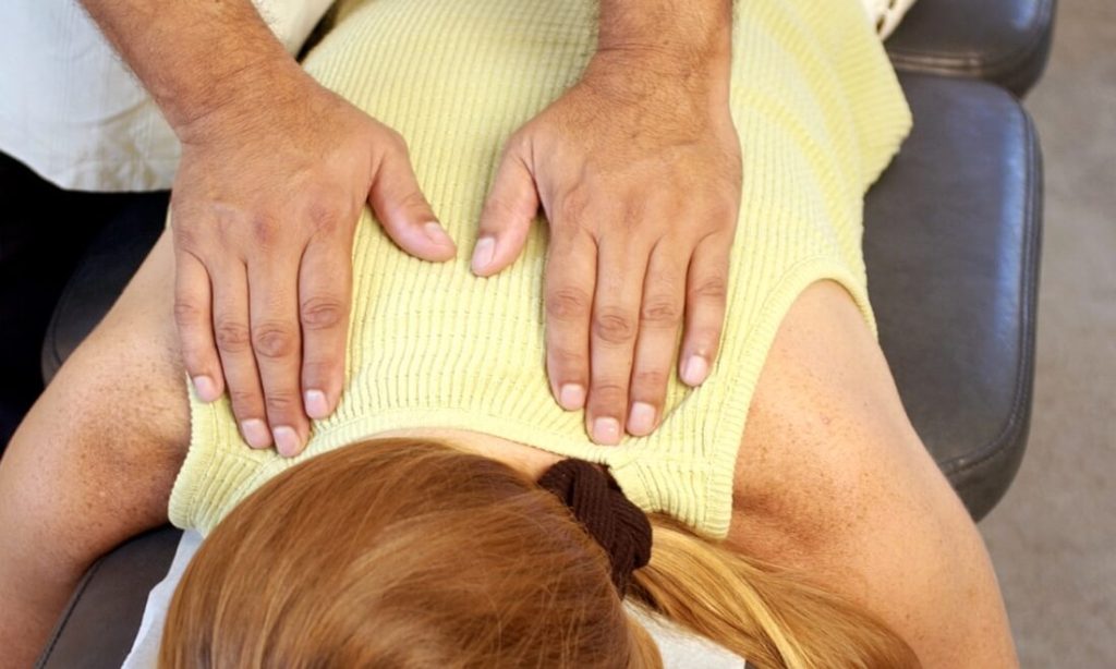 Dr. Aleksander Kanevsky, chiropractor performs chiropractic treatment on a patient